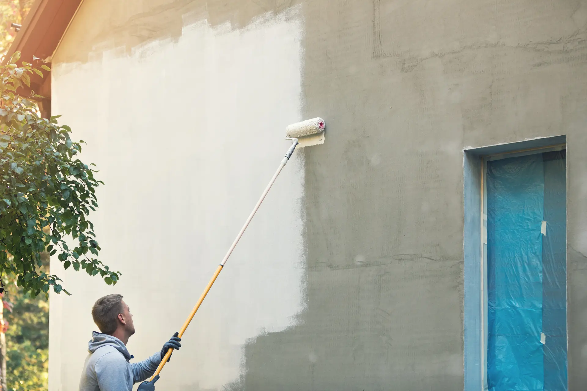 Pintor trabajando en una fachada en Ghecho